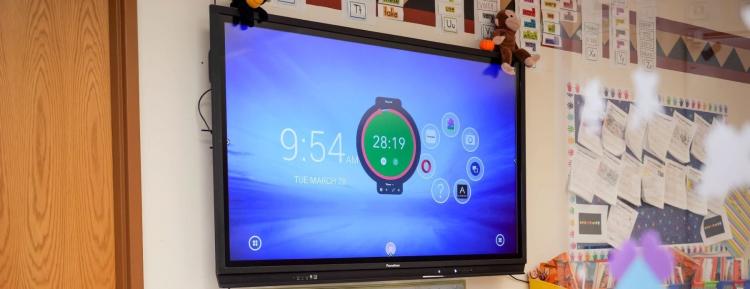 Large digital monitor for instructing students on classroom wall.